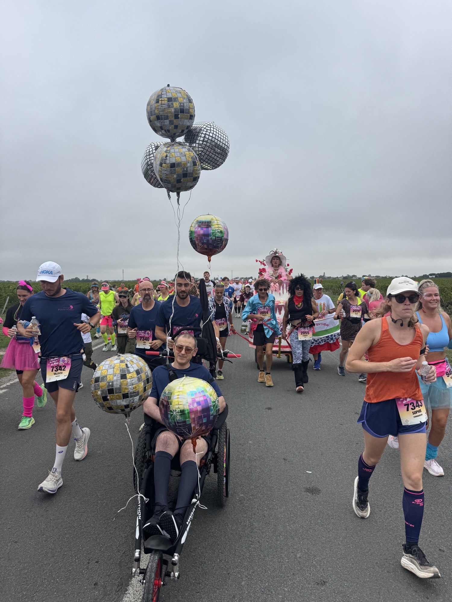 Stéphane Craviotto dans son fauteuil adapté, poussé par l'équipe de Pontet-Canet, au milieu des coureurs