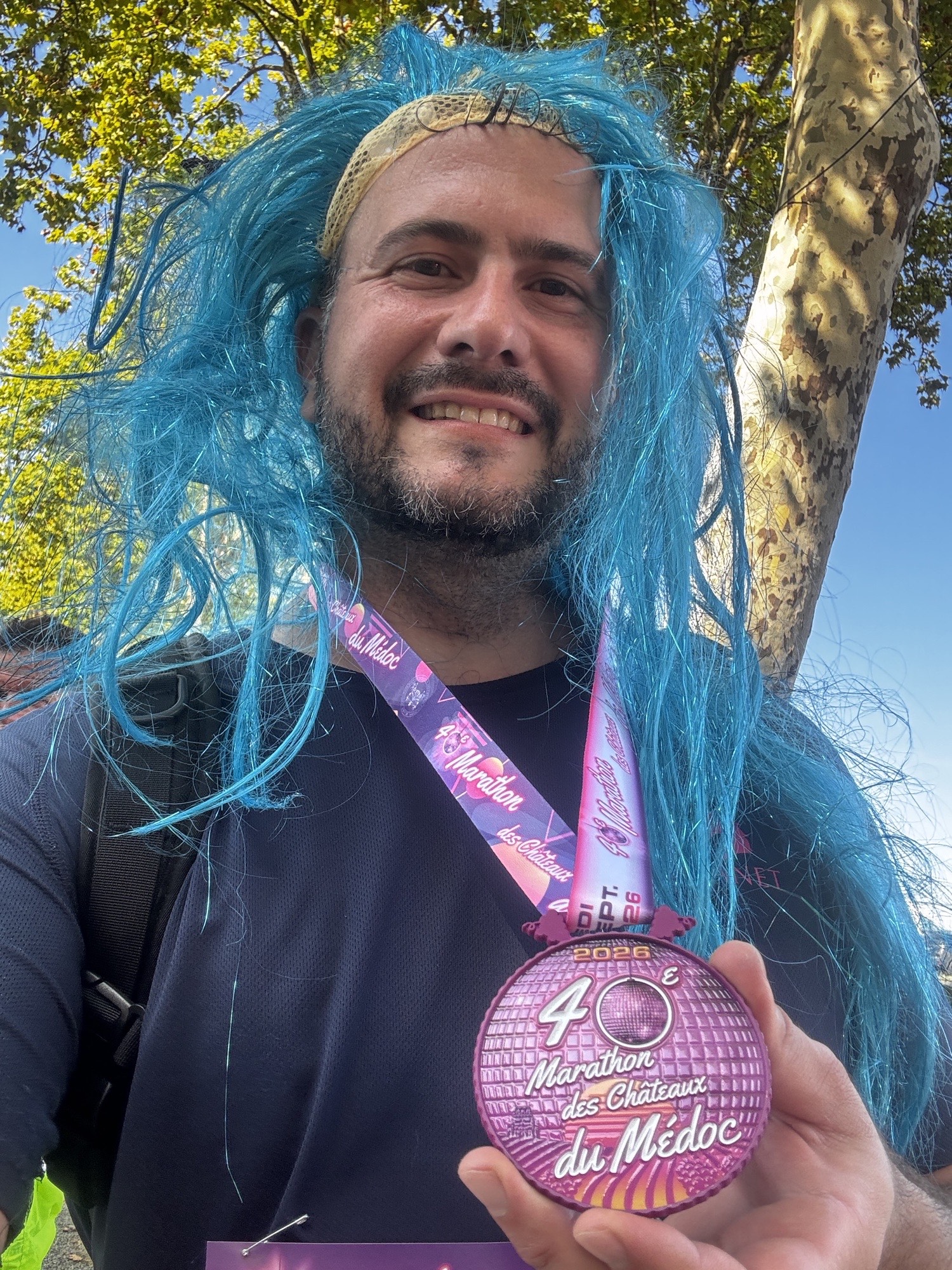 Xavier Lacombe montrant la médaille de finisher de la 40e édition du Marathon du Médoc